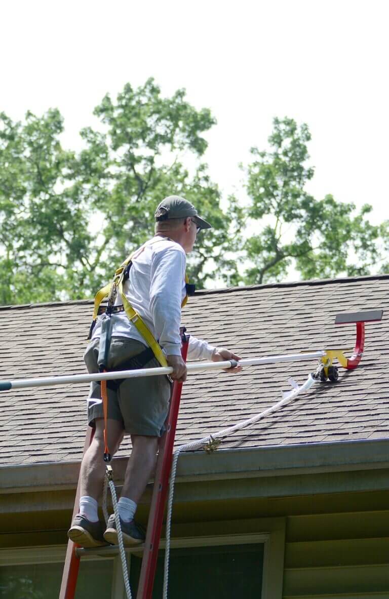 Man installing "The RidgePro" on a roof with extension pole