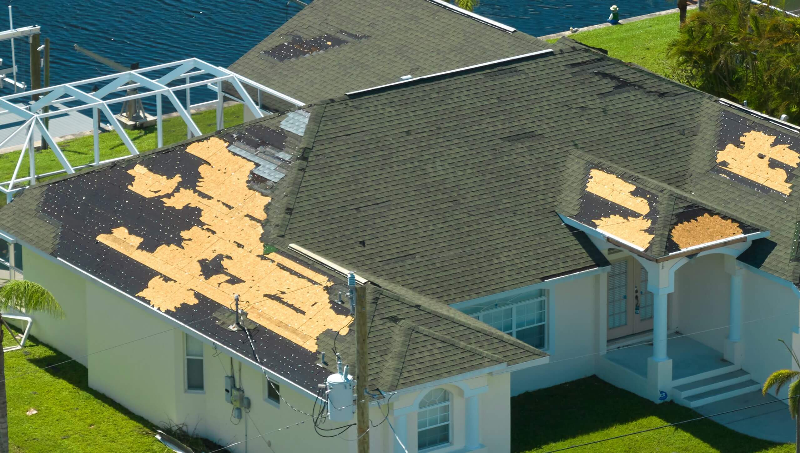 Damaged house roof with missing shingles after hurricane Ian in Florida. Consequences of natural disaster.